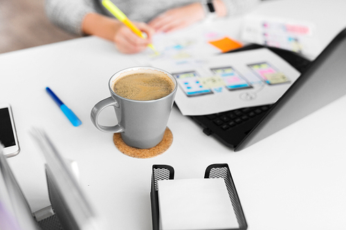 app design, technology and business concept - cup of coffee on office table