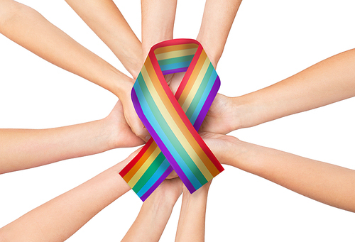 people, gay pride and homosexuality concept - human hands holding rainbow awareness ribbon
