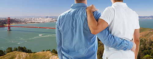 homosexual, same-sex marriage and tolerance concept - close up of happy male gay couple hugging over golden gate bridge in san francisco bay background