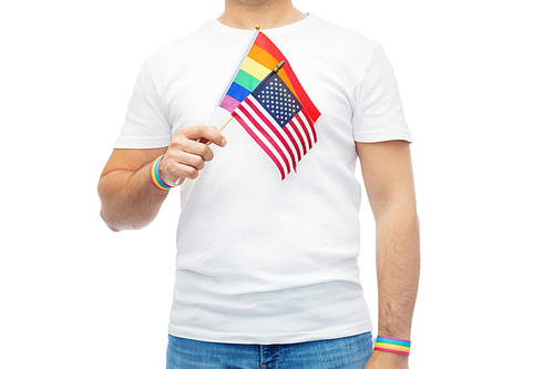 lgbt, same-sex relationships and homosexual concept - close up of man wearing gay pride rainbow awareness wristbands and holding american flag