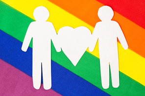 gay pride, homosexual and lgbt concept -male couple white paper pictogram on rainbow flag background