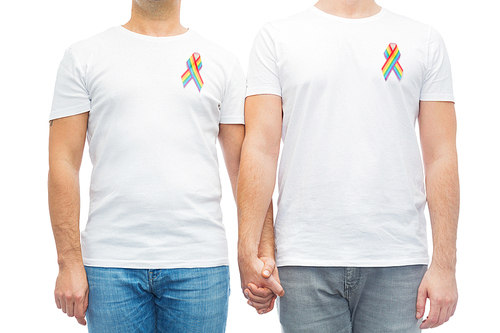 lgbt, same-sex relationships and homosexual concept - close up of male couple with gay pride rainbow awareness ribbons