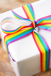 homosexual and lgbt concept - close up of gift box with gay pride awareness ribbon