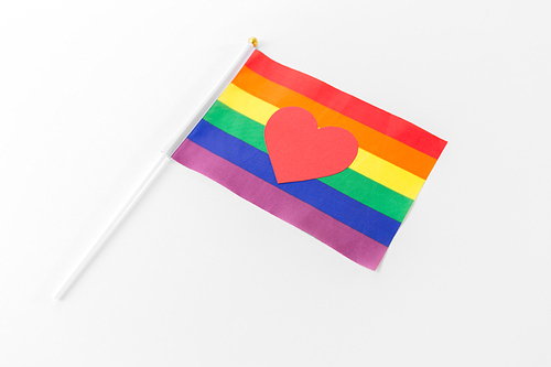 gay pride, homosexual and lgbt concept - red heart on rainbow flag over white background