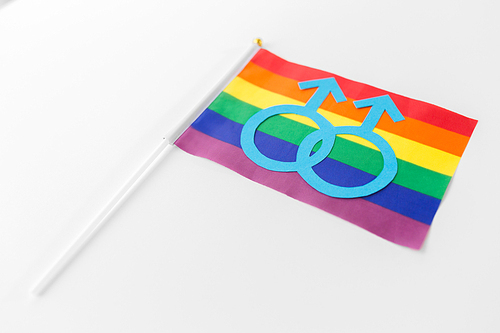 gay pride, homosexual and lgbt concept - male gender symbol on rainbow flag over white background