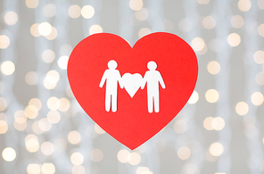 gay pride, homosexual, valentines day and lgbt concept - male couple white paper pictogram on red heart over festive lights background