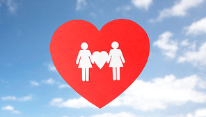gay pride, homosexual, valentines day and lgbt concept - female couple white paper pictogram on red heart over blue sky background