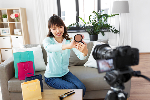 blogging, technology, videoblog and people concept - happy smiling asian beauty . with camera recording video blog about make up and cosmetics at home
