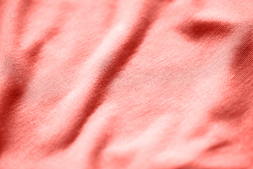 textile and texture concept - close up of cotton jersey fabric background in trendy color of the year 2019 living coral