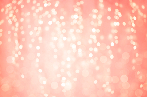 holidays and design concept - blurred bokeh lights in living coral, color of the year 2019