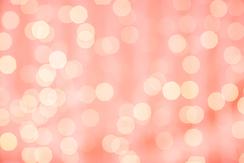 holidays and design concept - blurred bokeh lights in living coral, color of the year 2019