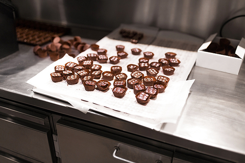 sweets production and industry concept - chocolate candies at confectionery shop