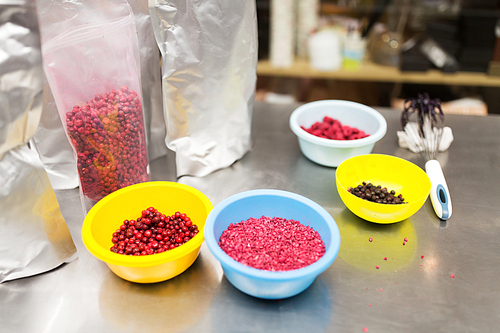 production, cooking and people concept - berries in bowls and whisk at confectionery shop kitchen