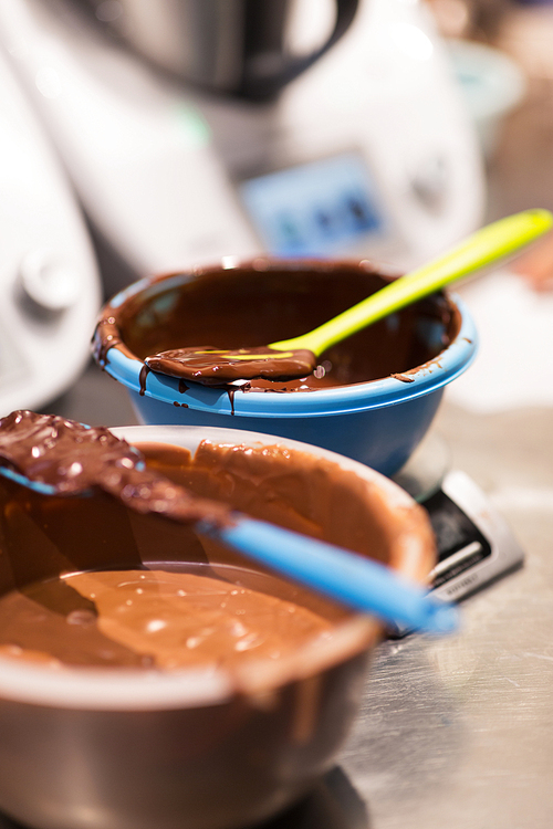 culinary and cooking concept - close up of chocolate cream in bowl at confectionery shop