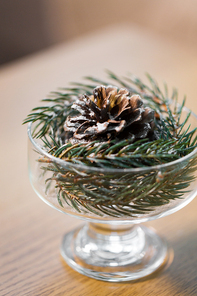 christmas concept - decoration of fir twig with pinecone in ice cream glass or dessert bowl