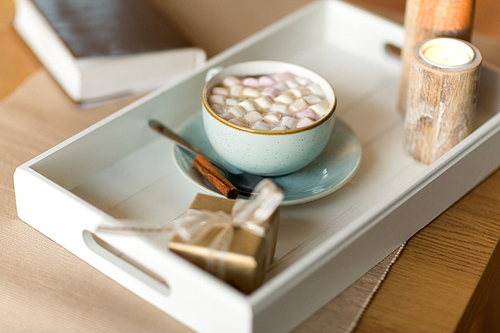 holidays and still life concept - hot chocolate with marshmallow, christmas gift and candles on table