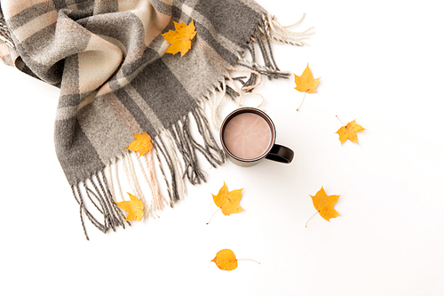 drinks and season concept - cup of hot chocolate, autumn leaves and warm blanket on white background