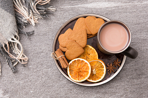 drinks and season concept - cup of hot chocolate with dried orange, heart shaped gingerbread cookies, cinnamon and anise on plate or tray and warm blanket