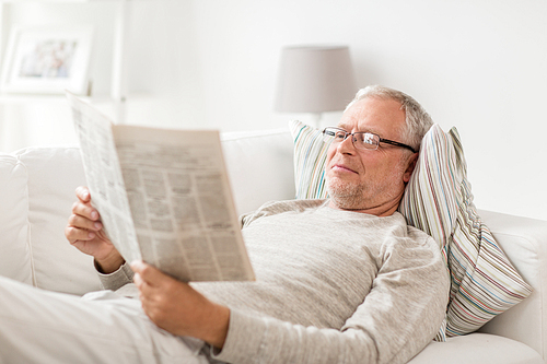 information, people and mass media concept - senior man reading newspaper at home
