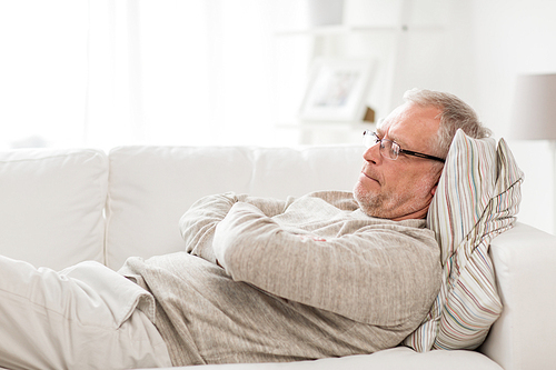 old age, problem and people concept - thoughtful senior man lying on sofa at home