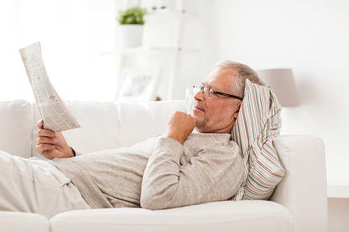 information, people and mass media concept - senior man reading newspaper at home