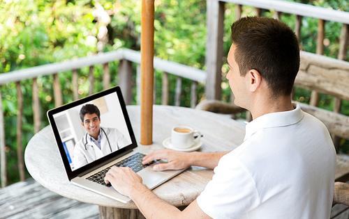 medicine, technology and healthcare concept - man or patient having video chat with doctor on laptop computer at summer terrace