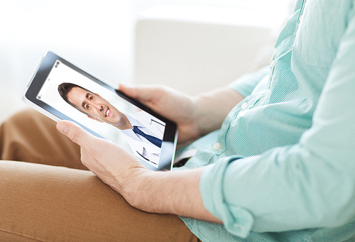 medicine, technology and healthcare concept - close up of man or patient having video chat with doctor on tablet pc computer at home