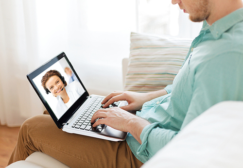 technology and communication concept - woman with laptop computer having video call with customer service operator at home