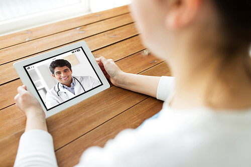 medicine, technology and healthcare concept - close up of woman or patient having video chat with doctor on tablet pc computer at home