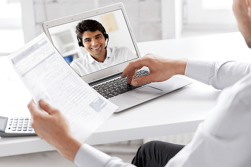 business, technology and communication concept - close up of businessman with laptop computer having video call with customer service operator, partner or secretary at office