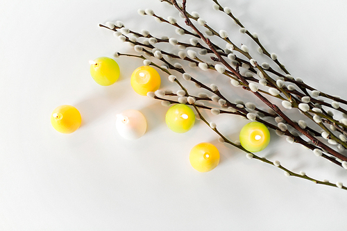 holidays and object concept - pussy willow branches and easter egg candles on white background