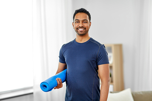 fitness, sport and healthy lifestyle concept - smiling indian man with exercise mat at home