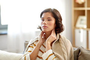 cold and health problem concept - sick woman touching her lymph nodes at home