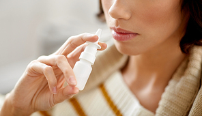 rhinitis, medicine and healthcare concept - close up of sick woman using nasal spray
