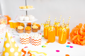 party drinks and food concept - close up of fruit juice or lemonade in decorated glass bottles with paper straws and popcorn