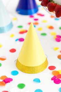 party props, accessory and festive concept - yellow birthday cap and confetti