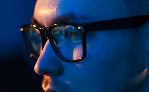 vision, hacking and technology concept - close up of hacker eyes in glasses looking at computer screen in darkness