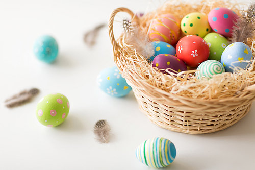 easter, holidays, tradition and object concept - close up of colored eggs in basket