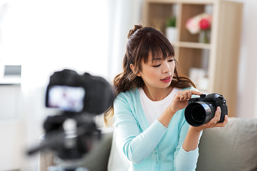 blogging, videoblog and technology concept - asian woman or . with photo camera recording video blog at home