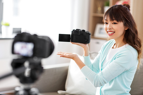 blogging, videoblog and technology concept - asian woman or . with photo camera recording video blog at home