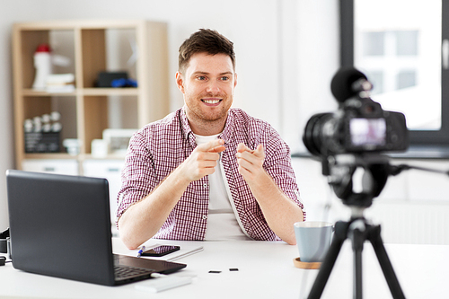 blogging, videoblog and people concept - male . recording video blog and pointing fingers to camera at home office