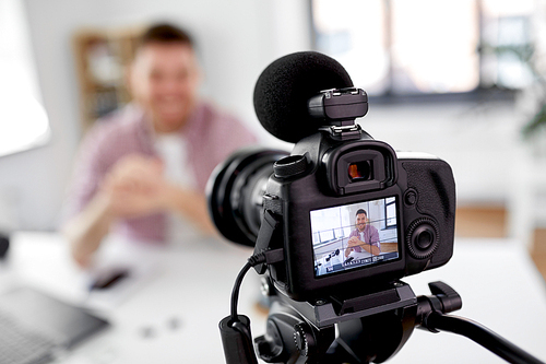 blogging, videoblog and videoblogging concept - close up of camera recording smiling male video . at home office