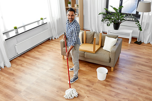 household, housework and people concept - happy indian man with mop and bucket cleaning floor at home