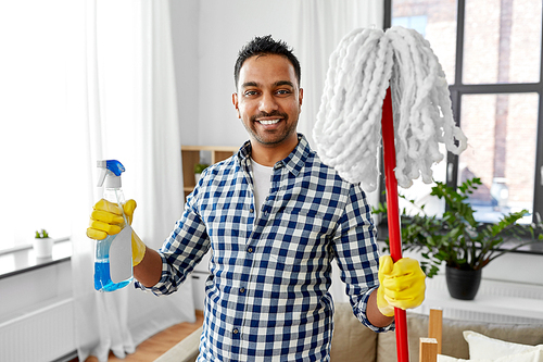 cleaning, housework and housekeeping concept - smiling indian man with mop and detergent at home