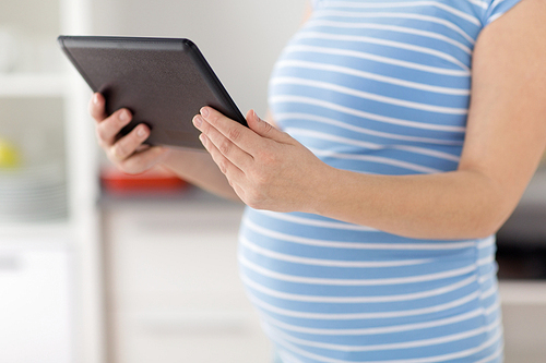 pregnancy and technology concept - close up of pregnant woman with tablet computer