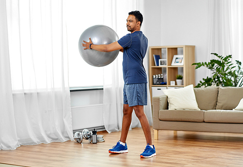 fitness, sport and healthy lifestyle concept - indian man exercising with ball at home
