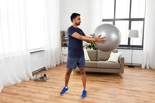 fitness, sport and healthy lifestyle concept - indian man exercising with ball at home