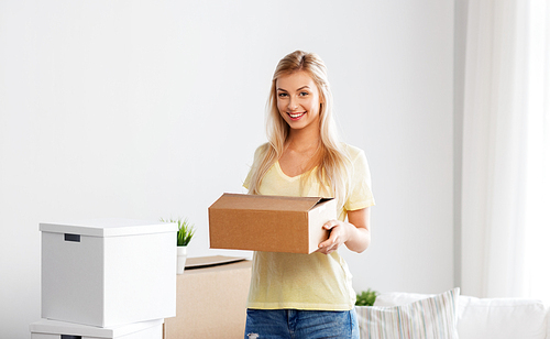 moving, people and real estate concept - happy woman with boxes at new home