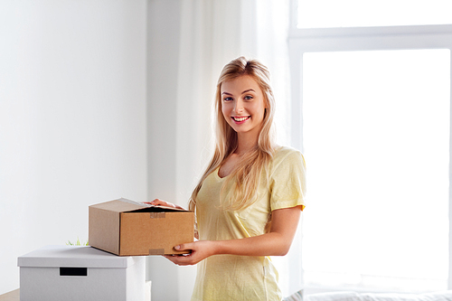 moving, people and real estate concept - happy woman with boxes at new home