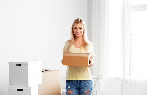 moving, people and real estate concept - happy woman with boxes at new home